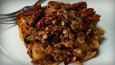 a white plate topped with granola and nuts next to a fork on top of it