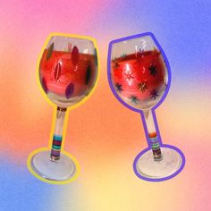 two wine goblets sitting side by side on a multicolored tablecloth