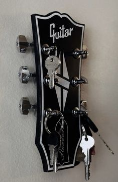 a guitar with keys attached to it hanging on the wall