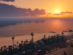 an aerial view of the beach and ocean at sunset or sunrise with palm trees in foreground