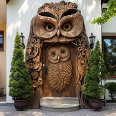 an owl statue is on display in front of a house with potted plants and trees