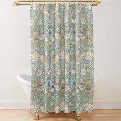 a shower curtain with an ornate design on it's side, in front of a bathtub