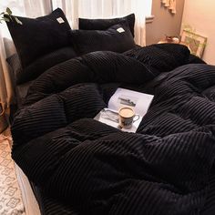 a black comforter and pillows on a bed