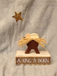 a nativity scene with a star and a wooden sign that says, a king is born