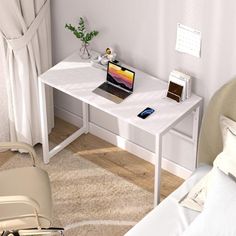 a small white desk with a laptop on it