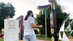 a man standing in front of a colorful sculpture