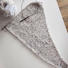 a crocheted piece of cloth next to a pair of scissors and yarn on a table