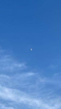 an airplane flying high in the sky with a half moon on it's side