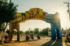 people riding motorcycles under an arch that says bievndos aquivede