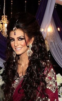 a woman with long dark hair wearing a red sari