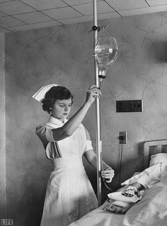 an old photo of a woman in a hospital bed with a nurse's stethoscope