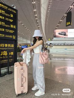 a woman is standing with her luggage at the airport