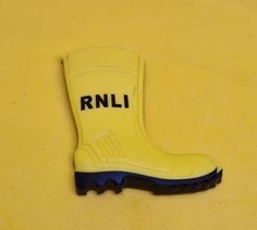 a yellow rubber boot with the word rnl on it sitting on a yellow surface