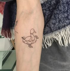 a person with a tattoo on their arm has a ducky drawing on it's leg