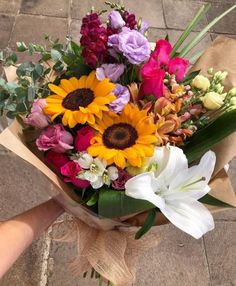 a bouquet of flowers sitting on top of a brown paper wrapped in burlock