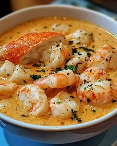 a bowl filled with shrimp and grits on top of a blue table