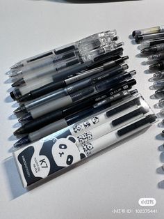 a bunch of pens sitting on top of a table next to each other with panda faces on them