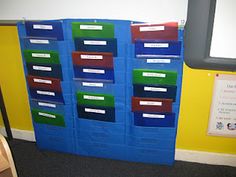 a room with several bins on the wall and a bulletin board in the corner