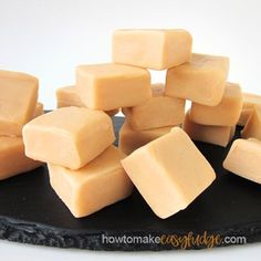 several cubes of cheese sitting on top of a black plate next to each other