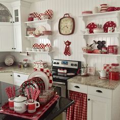 a kitchen with red and white decor on the walls, dishes and utensils