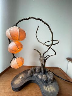 a lamp that is sitting on top of a wooden table next to a tree branch