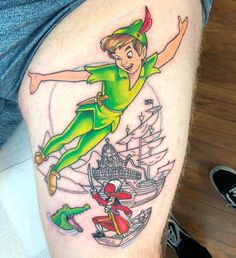 a man with a tattoo on his leg that has an image of peter pan and the little mermaid