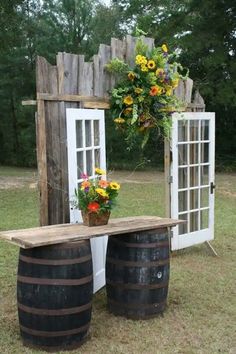 an outdoor area with two wooden barrels and a potted plant on the table next to it