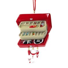 a christmas ornament hanging from a red box filled with shoes and other items