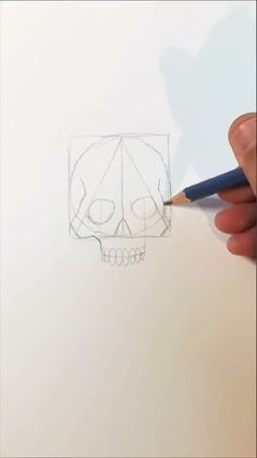 someone is drawing a skull with a pencil