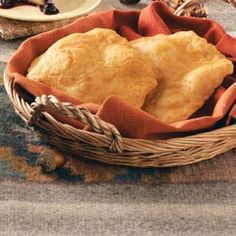 a basket filled with bread sitting on top of a table next to other food items