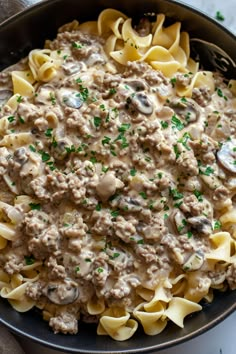 a skillet filled with pasta and mushrooms