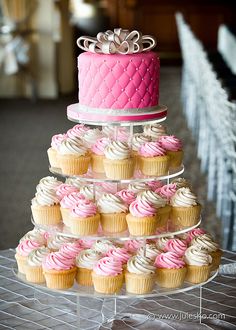 a tiered cake and cupcakes are on display at a wedding reception,