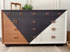 a dresser with several drawers on it and a plant sitting on top of the drawer