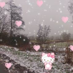 there is a hello kitty in the snow with hearts all over her face and behind her are trees