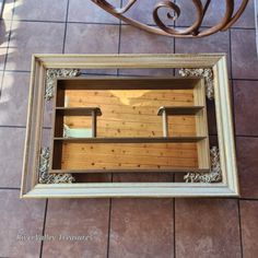 a mirror sitting on top of a tiled floor next to a chair and wall mounted shelf