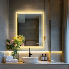 a bathroom with a sink, mirror and flowers in the vase on the counter top