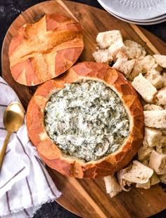 a wooden plate topped with bread and spinach dip