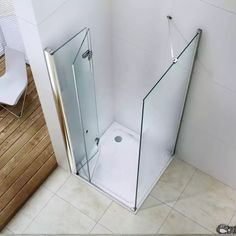 a bathroom with a glass shower door and wooden flooring on the side of the wall