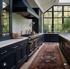 a large kitchen with blue cabinets and an area rug on the floor in front of it