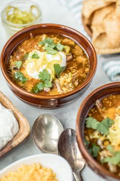 three bowls of mexican soup with sour cream, sour cream and tortilla bread