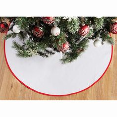 a christmas tree skirt with ornaments on it and a white circle rug in the middle