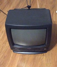 an old black television sitting on top of a wooden floor