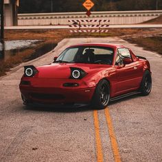 a red sports car is parked on the road