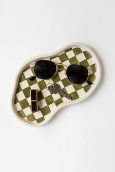 a green and white checkered tray with sunglasses on it