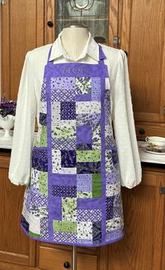 a purple and green patchwork apron on a mannequin