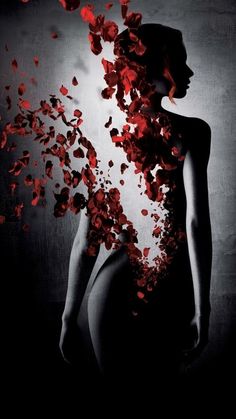 a woman is surrounded by petals in black and white photo with red light coming from her body