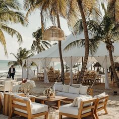 an outdoor seating area on the beach with palm trees