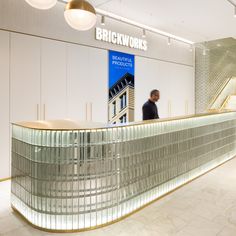 a man standing at the front of a building next to a glass counter with an advertisement on it