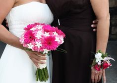 two bridesmaids holding bouquets of pink and white flowers