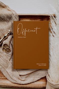 a brown book sitting on top of a wooden table next to a pair of scissors